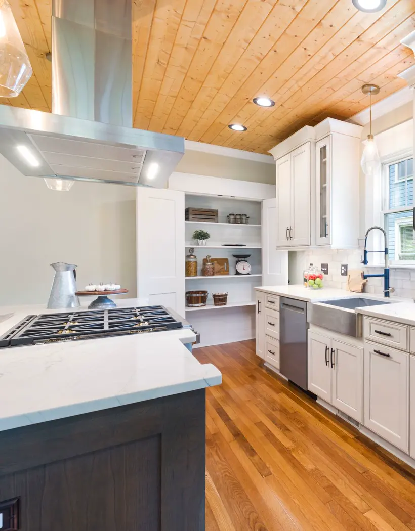 Cocina con isla, cielo raso de madera y piso de madera
