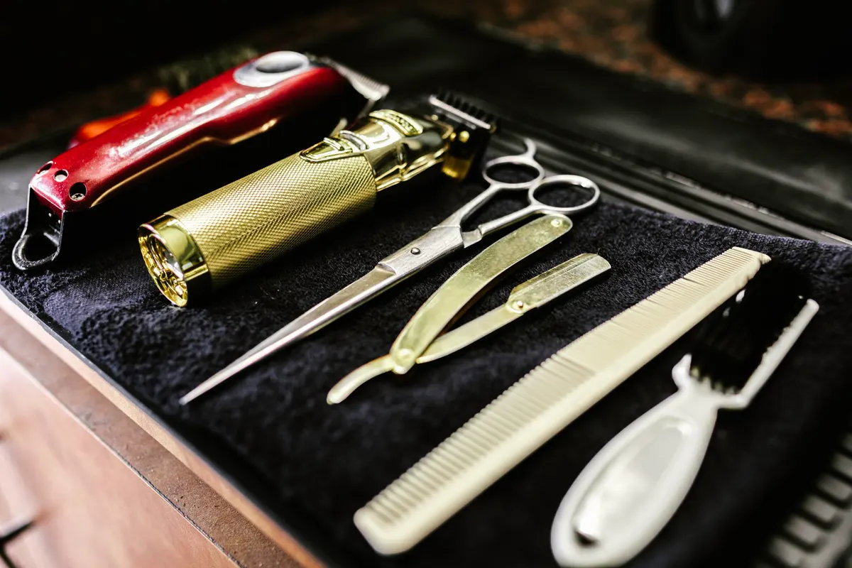 Herramientas de barbería ordenadas sobre una toalla negra