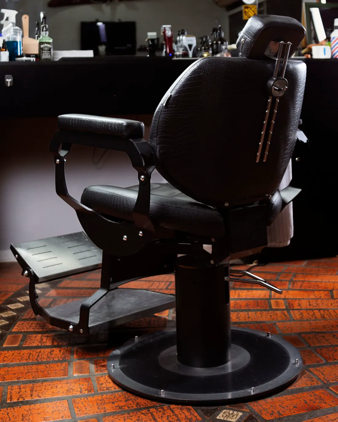 Sillón de barbero negro sobre piso de ladrillo