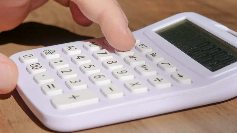 Mano usando una calculadora blanca