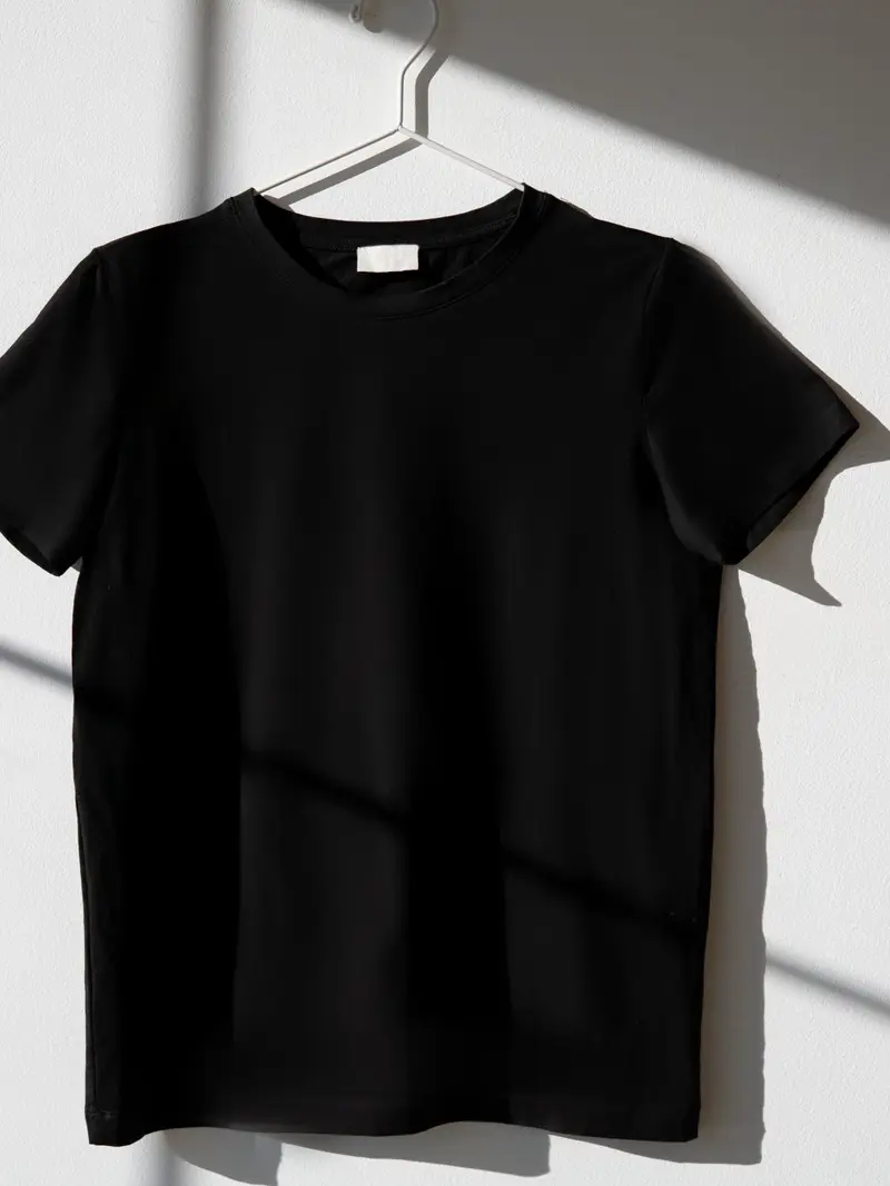 Polo negro de algodón en un gancho